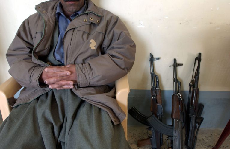 A Peshmerga sits next to weapons at a base February 24, 2004 in Halabja, Iraq. (Photo by Marco Di Lauro/Getty Images)