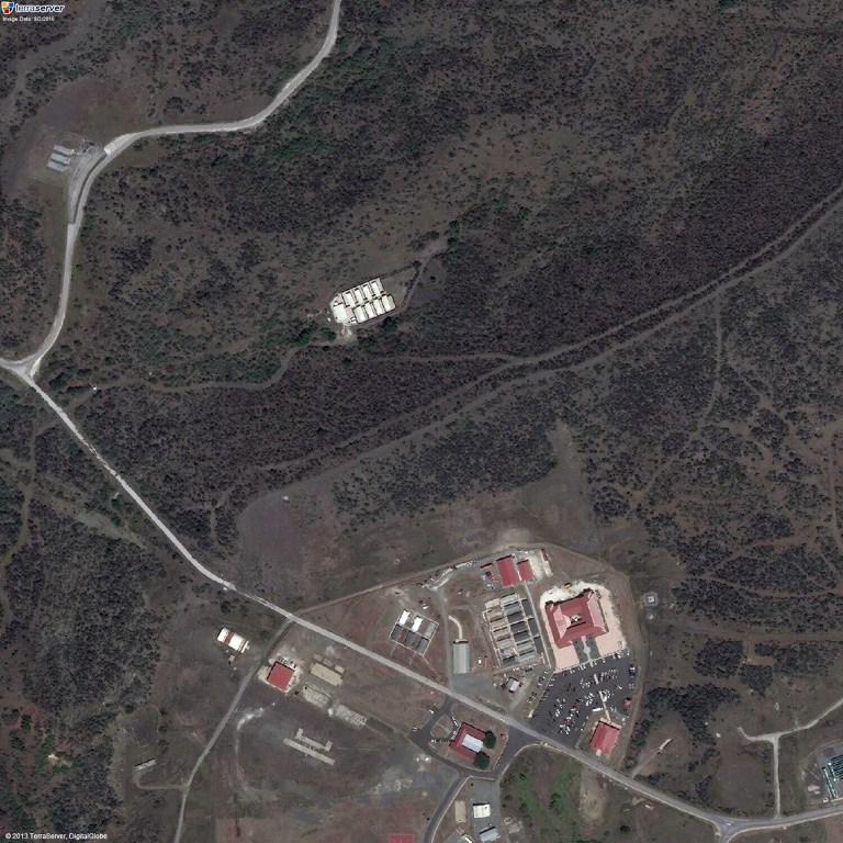 This satellite image provided by TerraServer.com and DigitalGlobe shows an image captured on Sept. 2, 2010, shows a portion of Naval Station Guantanamo Bay, Cuba, including the secret facility known as Penny Lane, upper middle in white. In the early years after 9/11, the CIA turned a handful of prisoners at the secret facility into double agents and released them. Current and former U.S. officials tell The Associated Press that the program helped kill terrorists. The program was carried out in the secret facility, built a few hundred yards from the administrative offices of the prison in Guantanamo Bay, bottom of image. The eight small cottages were hidden behind a ridge covered in thick scrub and cactus. (AP Photo/TerraServer.com and DigitalGlobe)