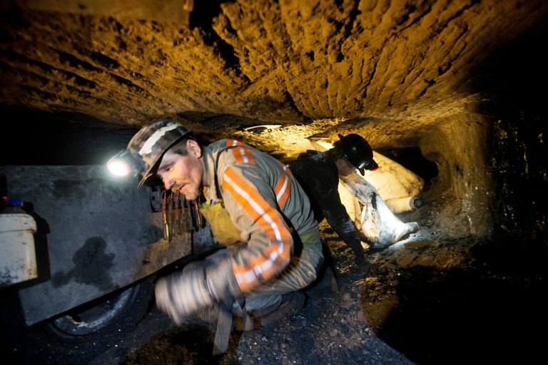Scottie Stinson, a coal miner of 16 years, crawls through a coal mine roughly 40-inches-high while securing the roof with bolts, Tuesday in Welch, W.Va. (AP Photo/David Goldman)
