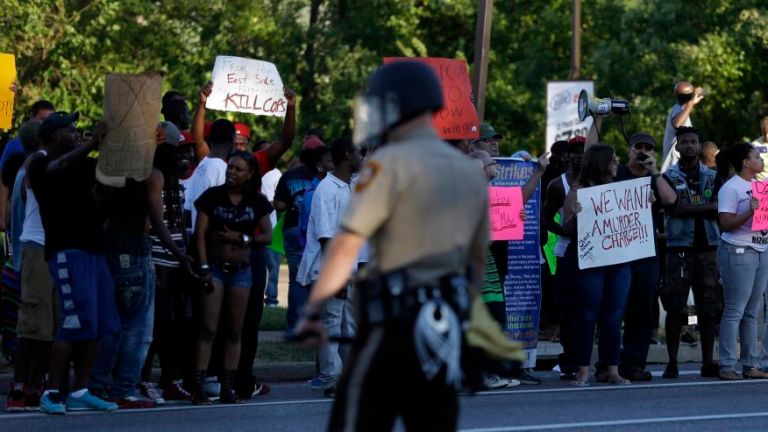Protesters recenlty lined a street as police stand watch in Ferguson, Mo. AP Photo