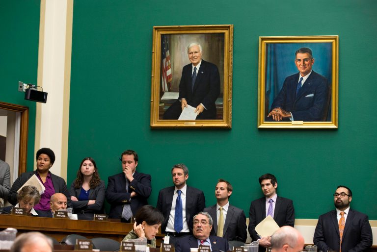 Congressional staffers watch a House Energy and Commerce Committee hearing on Thursday, Oct. 24, 2013, on Capitol Hill in Washington. (AP Photo/ Evan Vucci)