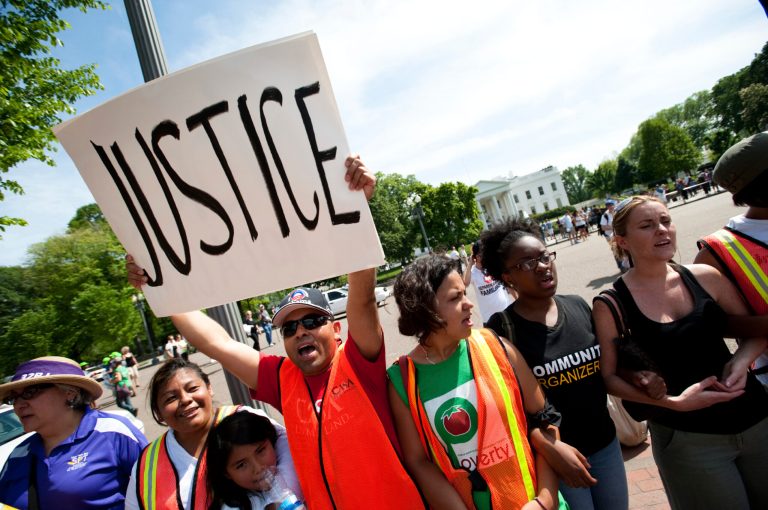 An immigration reform activist holds a sign reading 