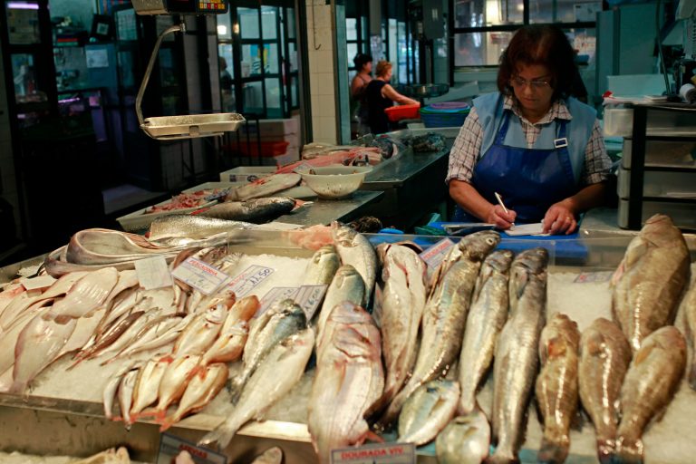 In this photo taken on May 15, 2014, a fishmonger checks sales as she waits for customers at Lisbon's Ribeira market. A thousand days on from its near-economic collapse, Portugal is ready to stand on its own again. On Saturday, May 17, 2014,  after an internationally-mandated makeover, Portugal will become the second euro country, after Ireland, to officially shake off its bailout shackles. (AP Photo/Francisco Seco)