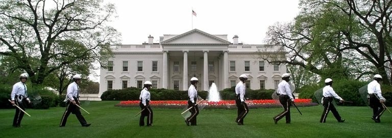 FILE - In this April 14, 2000 file photo, uniformed Secret Service officers with gas masks, batons, and shields march on the North Lawn of the White House in Washington.  As the number of demonstrators protesting against the World Bank and International Monetary Fund increases, so has security in the nation's capital.  President Clinton was out of town on a five-day trip to Georgia and California. The Secret Service is boosting security outside the White House following an embarrassing security breach in which an intruder with a knife scaled the White House fence, dashed across the lawn and made it all the way inside before agents managed to stop him.  (AP Photo/Khue Bui, File)