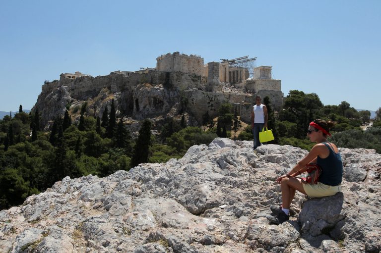   Tourists are seen in front of ancient Acropolis hill in central Athens, on Friday, June 15, 2012. Tourism and shipping are among the pillars Greek economy. Both are under strain amid speculation about whether Greece will have to abandon the euro in a chaotic and possibly economically debilitating exit. (AP Photo/Petros Karadjias)  