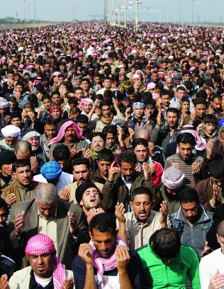 Iraqis gather for Muslim noon prayers, the highlight of the religious week, on the highway, which links Iraq with Jordan, during a protest in Fallujah, 40 miles (65 kilometers) west of Baghdad, Iraq, Friday, Feb. 1, 2013. Tens of thousands of Sunni protesters blocked a major highway in western Iraq on Friday, as an al-Qaida-affiliated group called on Sunnis to take up arms against the Shiite-led government. (AP Photo/ Khalid Mohammed)