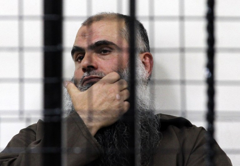 The radical al-Qaida-linked preacher Abu Qatada, looks on from behind bars at the Jordanian military court in Amman, Jordan, Thursday, June 26, 2014. A Jordanian military court on Thursday acquitted Abu Qatada of terrorism charges over a foiled 1999 plot to attack an American school in the Jordanian capital, Amman.(AP Photo/Raad Adayleh)