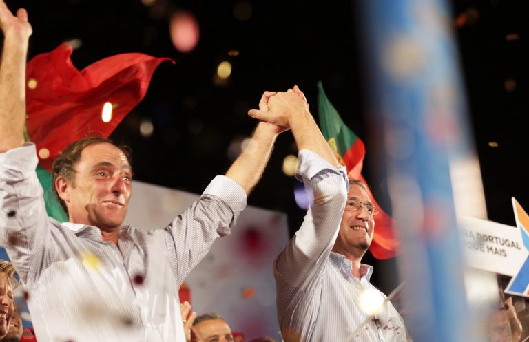 Portuguese Prime Minister Pedro Passos Coelho and Deputy Prime Minister Paulo Portas hold hands during an election campaign rally of their government coalition in Lisbon, Portugal, Friday, Oct. 2, 2015. (AP Photo/Armando Franca)