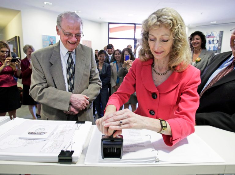 FILE - In this Aug. 15, 2011 file photo, California Secretary of State Debra Bowen certifies one of the new legislative and congressional maps  as California Citizens Redistricting Commission member Vincent Barabba watches at the Capitol in Sacraamento. Bowen, beset by frequent absences, has moved from her house into a mobile home park. Two months before Californians go to the polls to choose a governor, the state's top elections official tearfully acknowledged Friday, Sept. 5, 2014, that she has been consumed by a 