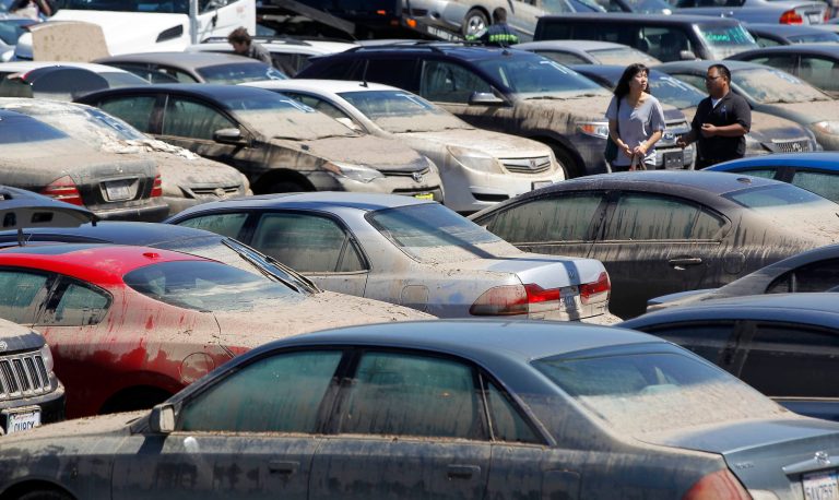 Car owners pick up personal property from their cars Tuesday, Aug. 5, 2014, that were damaged and recovered from a parking structure that flooded after a water main break July 29, on the UCLA campus in Los Angeles. At least 340 vehicles damaged by last week's massive flood on the campus of the University of California, Los Angeles are available for retrieval by their owners. The school has arranged to have insurance adjusters on site. (AP Photo/ Nick Ut )