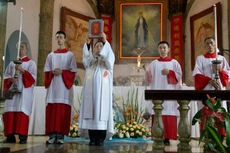 A Chinese priest holds up a bible during a mass at the 400-year-old Cathedral of the Immaculate Conception in Beijing, China, Friday, Aug. 15, 2014. Chinese Catholics on Friday cheered Pope Francisâ visit to neighboring South Korea, saying they hoped his trip to their region would help end the estrangement between Beijing and the Vatican. However, Chinaâs entirely state-run media imposed a virtual news blackout on his visit, ensuring the public at large would know little about Francisâ activities. (AP Photo/Ng Han Guan)