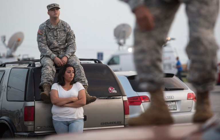 Lucy Hamlin and her husband, Spc. Timothy Hamlin, wait for permission to re-enter the Fort Hood military base, where they live, following a shooting on base on Wednesday in Fort Hood, Texas. (AP Photo/ Tamir Kalifa)