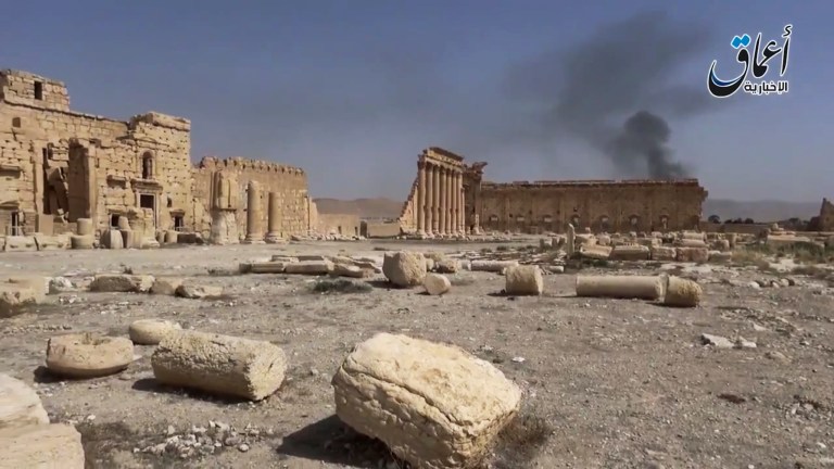 Smoke rises behind archaeological ruins in Palmyra, Syria. The video released by a media arm of the Islamic State group purportedly showed the archaeological ruins of Palmyra apparently undamaged. (Militant video via AP)