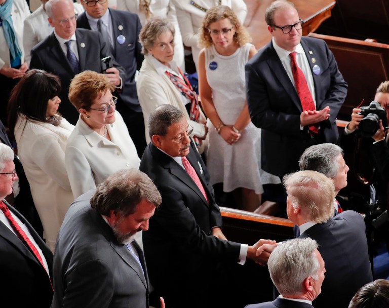 President Donald Trump, lower right, shakes hands with Rep. Sanford Bishop, D-Ga., center, as women Democratic members of Congress, wearing white, watch as Trump arrives on Capitol Hill in Washington, Tuesday, Feb. 28, 2017, to address a joint session of Congress. (AP Photo/Pablo Martinez Monsivais)