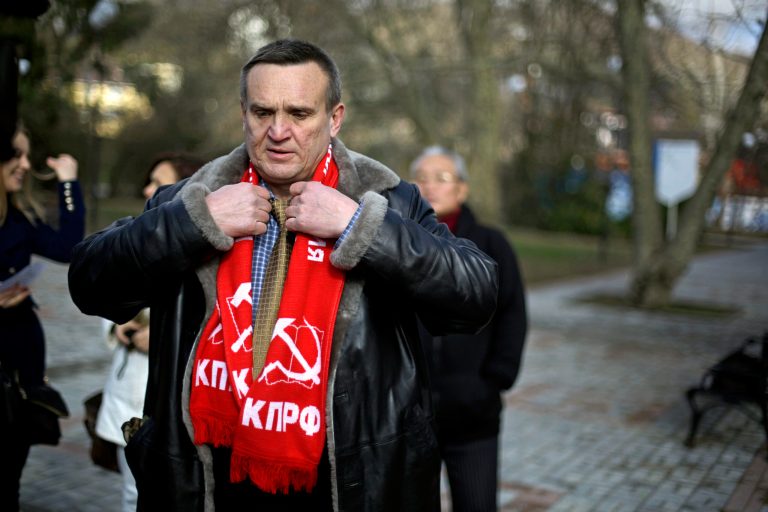 Igor Vasiliyev, head of the local branch of the Communist Party, adjusts his scarf decorated with a hammer and sickle, a symbol of the communist movement, as he leads a protest in the 50 Years of Victory in the Great Patriotic War Park to hold the first official demonstration in the designated Olympic protest area for the 2014 Winter Olympics, Saturday, Feb. 1, 2014, in Sochi, Russia. The protestors were members of the local branch of the Communist Party demonstrating for government benefits for Russian children of World War II born between 1928 and 1945. (AP Photo/David Goldman)