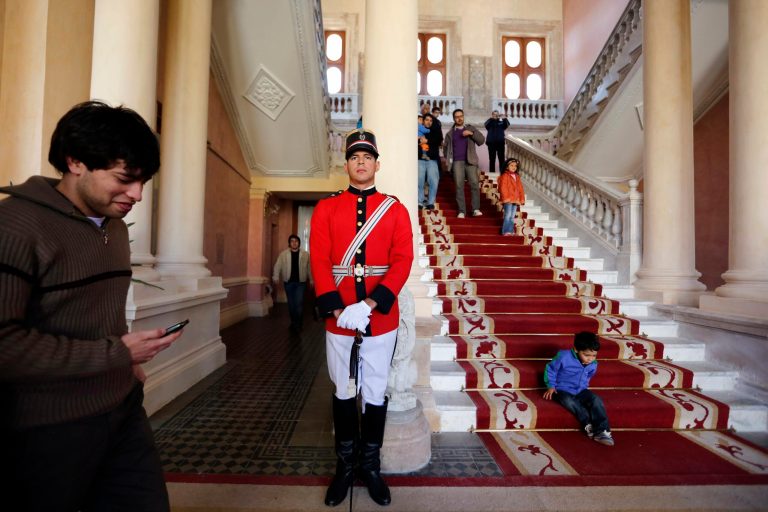 FILE - In this Aug. 10, 2013 file photo, a presidential guard officer provides security as people visit the government palace or 