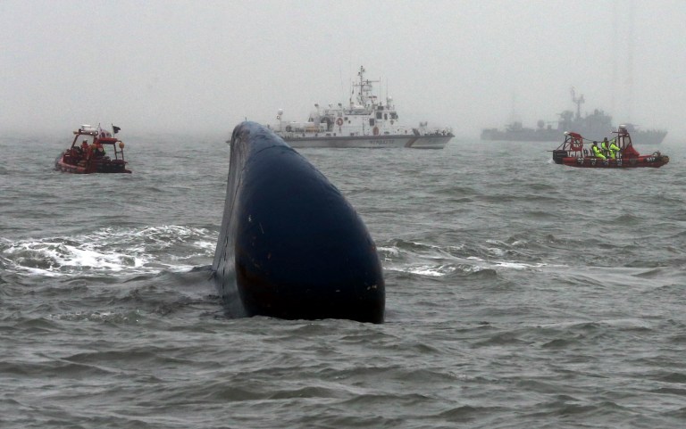 South Korean Coast Guard officers try to search missing passengers aboard the Sewol ferry in the water off the southern coast near Jindo, South Korea, Friday, April 18, 2014. The doomed ferry's captain delayed evacuation for half an hour after a South Korean transportation official ordered preparations to abandon ship, raising more questions about whether quick action could have saved scores of passengers still missing Friday and feared dead, according to a transcript of the ship-to-shore exchange and interviews with a crewmember. (AP Photo/Yonhap) KOREA OUT
