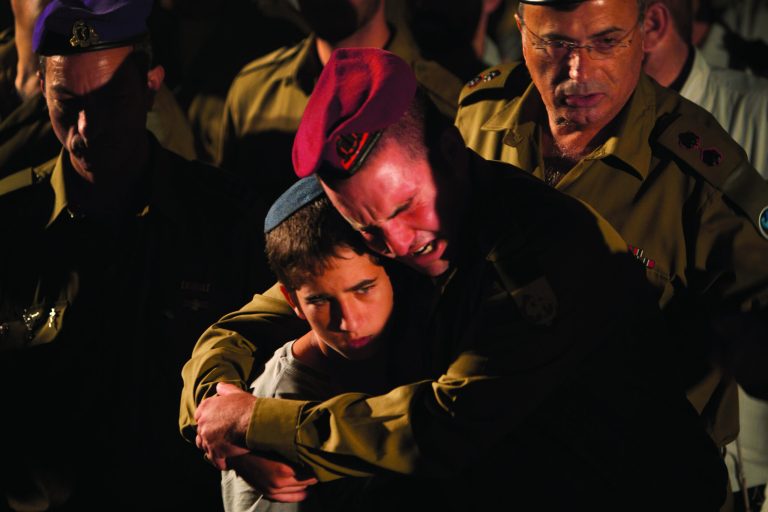 Israeli soldiers and relatives react during the funeral of Cpl. Netanel Yahalomi, 20, in the Israeli city of Modiin, early Sunday, Sept. 23, 2012. Yahalomi was killed Friday in a shootout between Islamic militants and Israeli troops along Israel's southern border with Egypt. The Israeli troops returned fire, killing the militants. (AP Photo/Oded Balilty)
