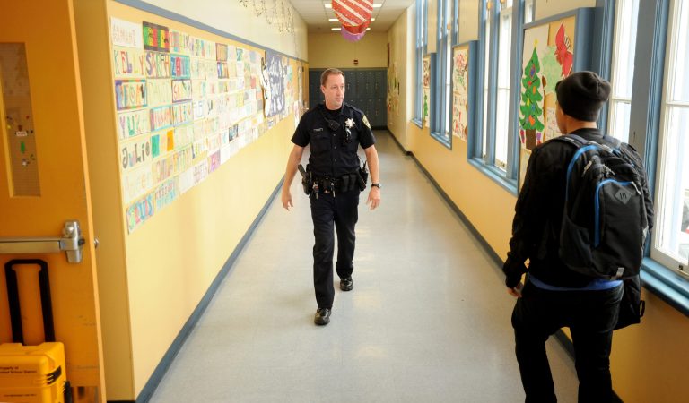   FILE - In this Dec. 17, 2012 photo, Officer Rick Moore of the Oakland school district police patrols Oakland Technical High School in Oakland, Calif. The National Rifle Association on Friday, Dec. 21 2012 called for the placement of an armed police officer in every school, but parents and educators questioned how safe such a move would keep kids, whether it would be economically feasible and how it would alter student life. Their reactions ranged from supportive to disgusted. (AP Photo/Noah Berger, File)  