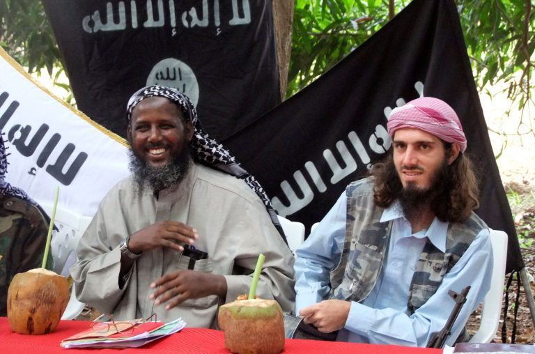 In this Wednesday, May 11, 2011 file photo, American-born Islamist militant Omar Hammami, 27, also known as Abu Mansur al-Amriki, right, and deputy leader of al-Shabab Sheik Mukhtar Abu Mansur Robow, left, sit under a banner which reads 