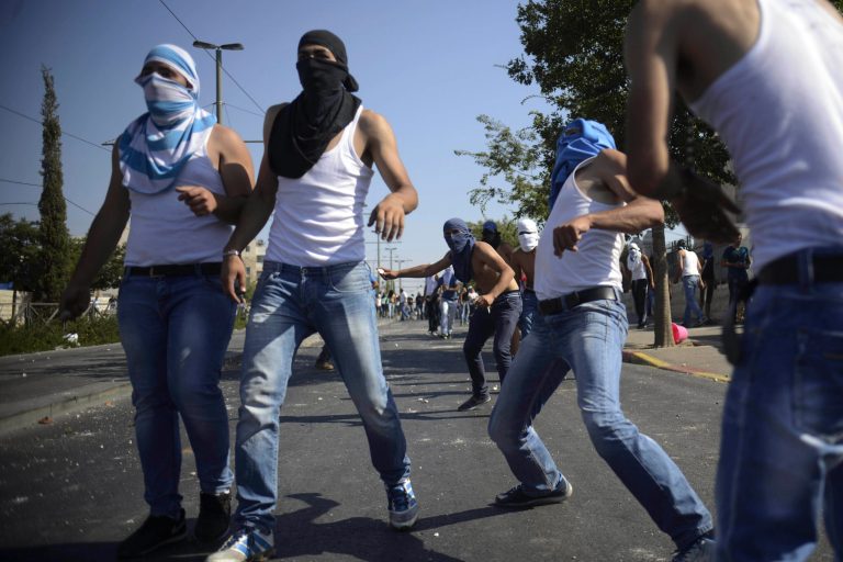 Palestinians throw rocks as they clash with Israeli security forces during the funeral of 16-year-old Mohammed Abu Khdeir in Jerusalem on Friday, July 4, 2014. Israeli police clashed with Palestinian protesters in Jerusalem on Friday as thousands of people converged on a cemetery for the burial of an Arab teenager, who Palestinians say was killed by Israeli extremists in a suspected revenge attack. (AP Photo/Mahmoud Illean)