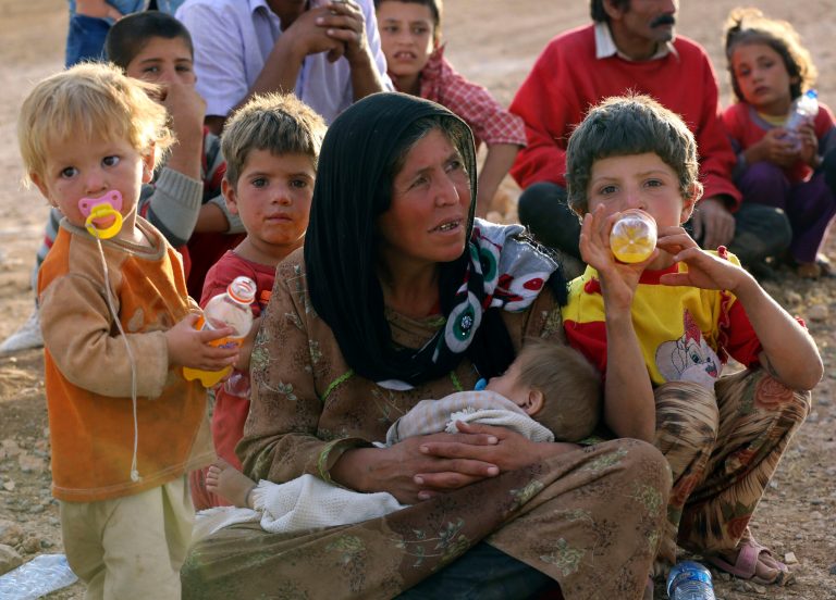IN this Thursday, Sept. 25, 2014 photo, a Syrian refugee mother rests with her children at a crossing gate near Suruc, Turkey. Refugees have been streaming into Turkey from Syria to find safety. (AP Photo/Burhan Ozbilici)