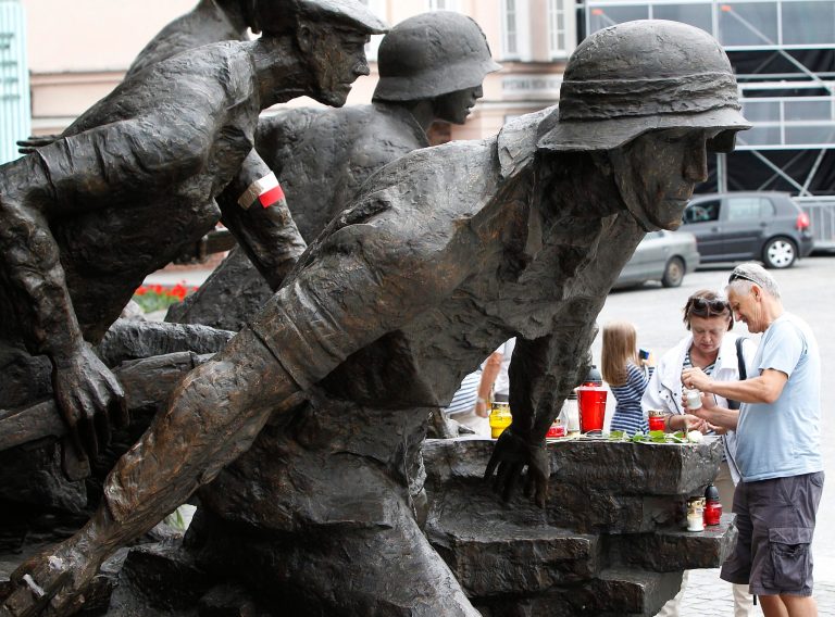 People light candles at the Warsaw Uprising monument  in Warsaw,  Friday, Aug. 1, 2014. On the 70th anniversary of the Warsaw Uprising, Poland is honoring the fighters and victims of the rebellion against Nazi Germans by laying wreaths, sounding sirens and singing insurgent tunes. On Aug. 1, 1944, thousands of poorly-armed city residents rose up against the German forces to try to take control of the city ahead of the advancing Soviet army. They held on for 63 days before being forced to surrender. Almost 200,000 people were killed. The Nazis expelled the survivors and set the city ablaze. (AP Photo/ Czarek Sokolowski)