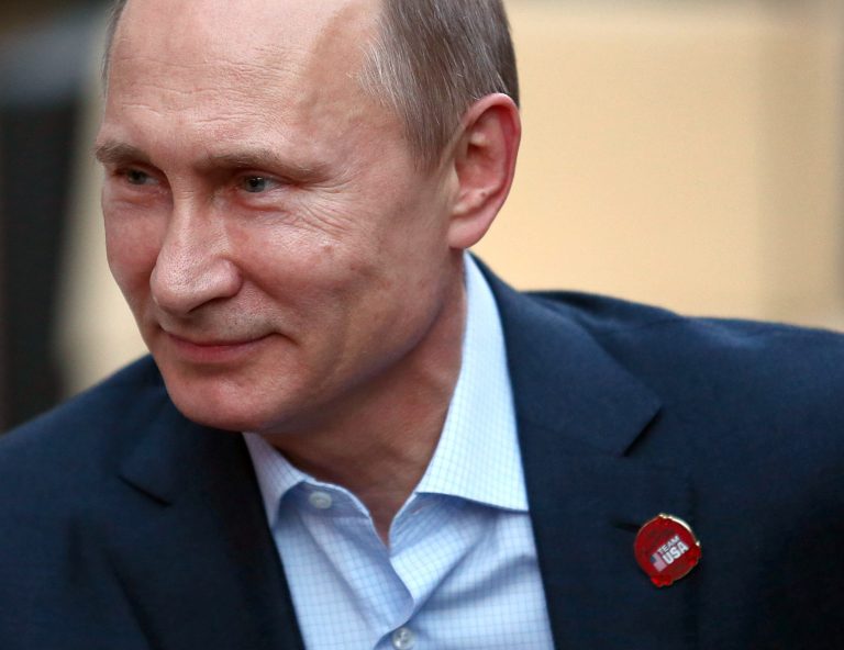 Russian President Vladimir Putin wears a Team USA pin while visiting USA House in the Olympic Village during the 2014 Winter Olympics on Friday, Feb. 14, 2014, in Sochi, Russia.  (AP Photo/Marianna Massey, USOC Pool)