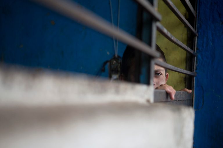 A boy peers out through the door of a cell-like room inside The Great Family group home in Zamora, Mexico, Thursday, July 17, 2014. After a police raid on the refuse-strewn group home Tuesday, residents of the shelter told authorities that some employees beat residents, fed them rotting food or locked them in a tiny 