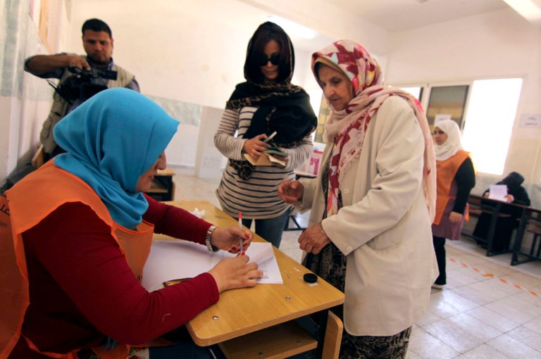 Defying the turmoil roiling their nation Libyans vote in parliament elections, the third nationwide balloting since the toppling of longtime dictator Moammar Gadhafi, at a polling station in Benghazi, Libya, Wednesday, June 25, 2014. The vote is a key step in transition for the oil-rich Libya, embroiled in deep political chaos and instability mainly because of the absence of a strong military and police force. Heavily armed militias, born out of the rebel groups that toppled Gadhafi, now are the main power in the country. (AP Photo/Mohammed el-Shaiky)