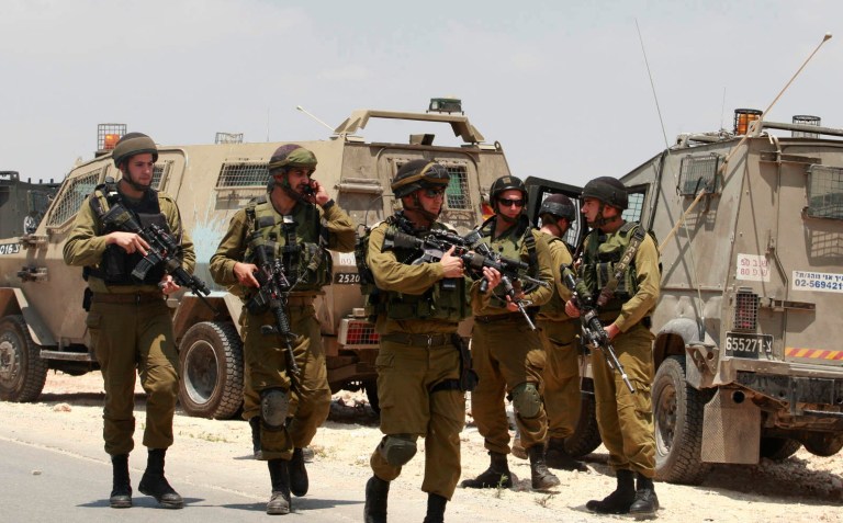 Israeli soldiers deploy near the West Bank city of Hebron, Friday, June 13, 2014. Israeli soldiers searched the West Bank on Friday for three missing teenagers from nearby settlements, one of them a U.S. citizen, amid fears Palestinian militants abducted them, authorities said. (AP Photo/Nasser Shiyoukhi)