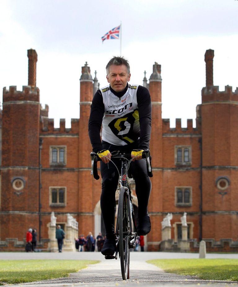   In this Friday, April 20, 2012 photo Surrey County Councilâs Alan Flaherty who has been involved in designing the Olympic road cycle course, and helping athletes to test it out, poses for a photograph in front of Hampton Court Palace, Hampton, England. Away from the bustle of London's Olympic stadium, the Summer Games will also showcase the country's postcard perfect rural charms, and highlight centuries of its history. (AP Photo/Kirsty Wigglesworth)  