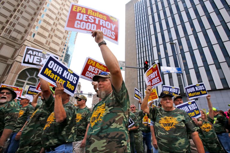Some 5000 union members, led by the United Mine Workers of America, march outside the William S. Moorhead Federal Building, right rear, Thursday, July 31, 2014. (AP Photo/Gene J. Puskar)