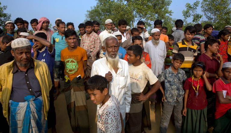 Rohingya refugees stand and watch as others receive relief material at Kutupalong refugee camp near Cox's bazar, Bangladesh, Tuesday, Jan. 16, 2018. (AP Photo/Manish Swarup)