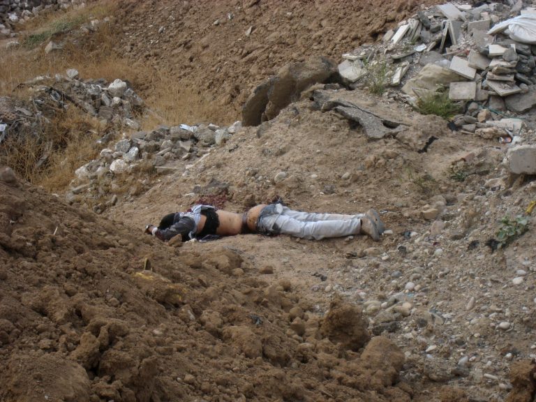 The dead body of a thwarted suicide bomber lies outside of the Mustafa mosque after being killed by security forces in Kirkuk, 180 miles (290 kilometers) north of Baghdad, Iraq, Friday, May 17, 2013. Elsewhere, a bomb killed dozens of people at a Sunni mosque in central Iraq, hitting worshippers as they were emerging from Friday prayers, security officials said. The attack in Baqouba comes after two days of attacks, many in Shiite districts, left tens of people dead. Attacks against Sunni mosques have also been on the rise recently, raising fears that the country is slipping into a new round of sectarian violence. (AP Photo/Emad Matti)