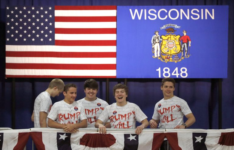 Supports of Republican presidential candidate, Donald Trump, wear shirts with the words Trump's Wall written on them, before a town hall Saturday, April 2, 2016, in Rothschild, Wis. (AP Photo/Charles Rex Arbogast)