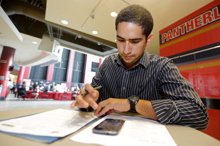 FILE - In this Aug. 19, 2014 file photo, Freddy Jerez, of Hollywood, Fla., fills out a job application during a job fair in Sunrise. Fla. A quarterly survey by the National Association for Business Economics released Monday, Oct. 20, 2014 found that only 24 percent of companies increased wages and salaries in the July-September quarter. That's down from 43 percent in the April-June quarter and the first drop after three straight increases. (AP Photo/Alan Diaz, File)