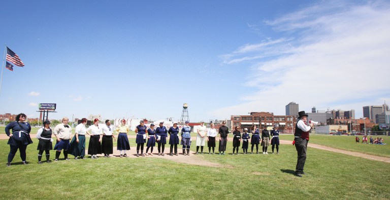 Members of the  Detroit River Belles Ladies Vintage Base Ball Club and  the Derby Dimesare line up prior to the game for introductions on Sunday, July 13, 2014 in Detroit.  The special charity baseball game was played at Old Tigers stadium.  (AP Photo/Detroit Free Press, Regina H. Boone)  DETROIT NEWS OUT;  NO SALES