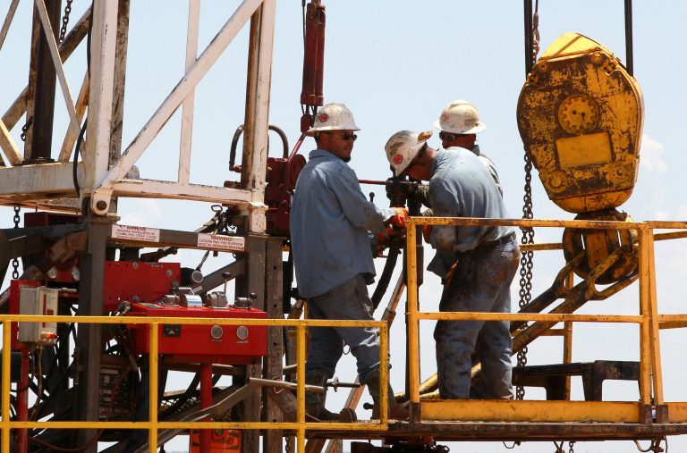 Workers are pictured on a drilling rig near Calumet, Okla., in July 2012. (AP Photo/Sue Ogrocki)