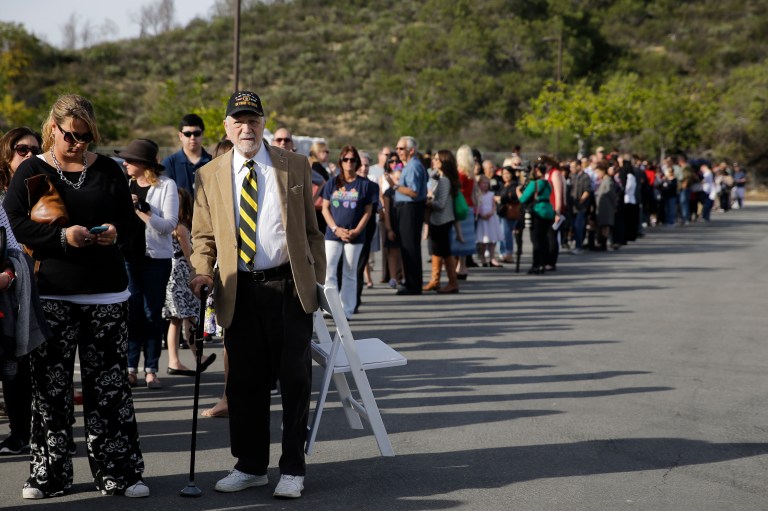 People wait in line to board buses to take them to the Ronald Reagan Presidential Library for the public viewing of former First Lady Nancy Reagan Wednesday, March 9, 2016, in Simi Valley, Calif. (AP Photo/Jae C. Hong)