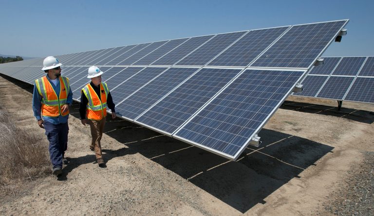 Solar Tech Joshua Valdez, left, and Senior Plant ManagerTim Wisdom walk past solar panels and at a Pacific Gas and Electric Solar Plant, Thursday, Aug. 17, 2017, in Vacaville, Calif. (AP Photo/Rich Pedroncelli)