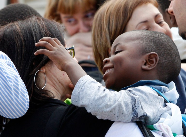 Congolese children are welcomed by their Italian adoptive relatives as they disembark after landing from Kinshasa, at Ciampino's military airport, on the outskirts of Rome, Wednesday, May 28, 2014. The children ran excitedly into their parents' arms after an overnight flight from Congo. Italy had worked since late last year to allow them to reach Italy. Congo had suspended all international adoptions citing fears some adopted children might later have been trafficked. None of the allegations involved adoptions by Italians. The parents were forced to leave Congo without their children after their visas expired. (AP Photo/Riccardo De Luca)