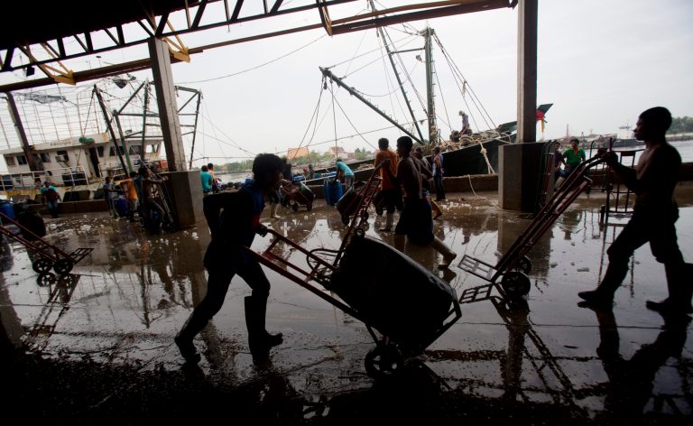 Migrant workers unload frozen fish from a boat at a fish market in Samut Sakhon Province, west of Bangkok, Friday, June 20, 2014. The United States has blacklisted Thailand and Malaysia for failing to meet its minimum standards in fighting human trafficking, a move that could strain relations with two important U.S. partners in Asia. Thailand had mounted a determined campaign to prevent a downgrade that could exact a reputational cost on its lucrative seafood and shrimp industries for which America is a key market. (AP Photo/Sakchai Lalit)