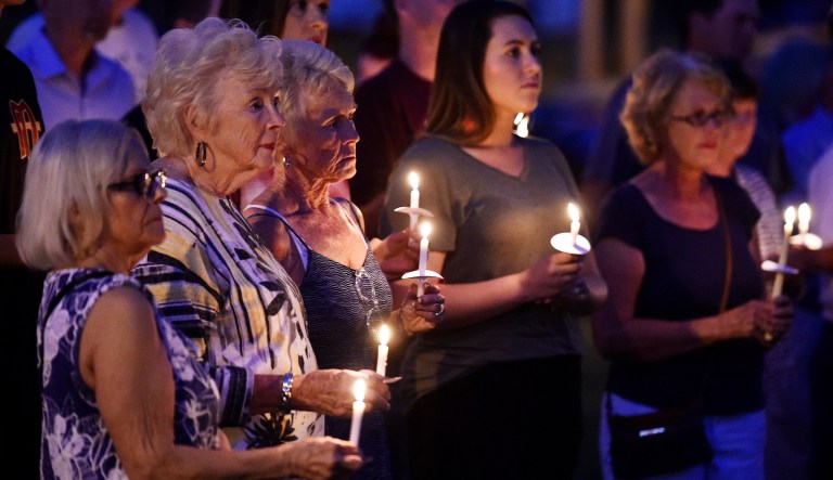 People hold candles during a vigil for the victims of the church shooting. A man charged in the shooting at the church expressed suicidal thoughts in June and had a volatile relationship with a woman that twice involved law enforcement this year, according to police records. (Andrew Nelles/The Tennessean via AP)