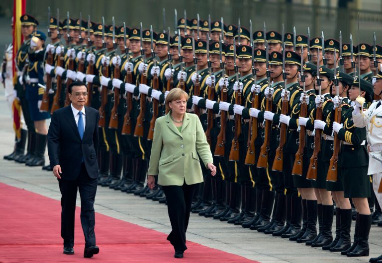 German Chancellor Angela Merkel, right, and Chinese Premier Li Keqiang, left, review an honor guard during a welcome ceremony outside the Great Hall of the People in Beijing, China Monday, July 7, 2014. (AP Photo/Andy Wong)