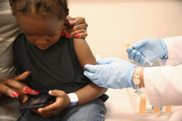 Shakeithia Roberts holds her son, Jermaine Roberts , as pediatrician Amanda Porro M.D. administers a measles vaccination during a visit to the Miami Children's Hospital on May 16, 2014 in Miami, Florida. (Photo by Joe Raedle/Getty images)
