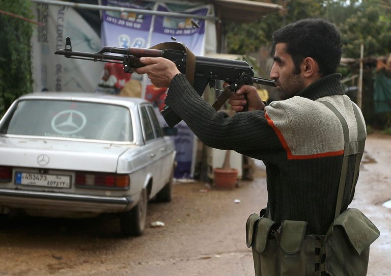   A Sunni gunman fires his weapon during clashes that erupted between pro and anti-Syrian regime gunmen in the northern port city of Tripoli, Lebanon, Wednesday, Dec. 5, 2012. Gunmen loyal to opposite sides in neighboring Syria's civil war battled in the streets of northern Lebanon at a time of deep uncertainty in Syria, with rebels closing in on President Bashar Assad's seat of power in Damascus. (AP Photo/Hussein Malla)  