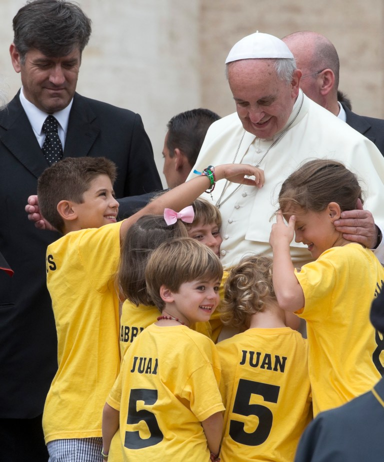 Pope Francis hugs a group of Spanish children coming from Madrid at the end of his weekly general audience in St. Peter's Square at the Vatican, Wednesday, June 25, 2014. (AP Photo/Alessandra Tarantino)