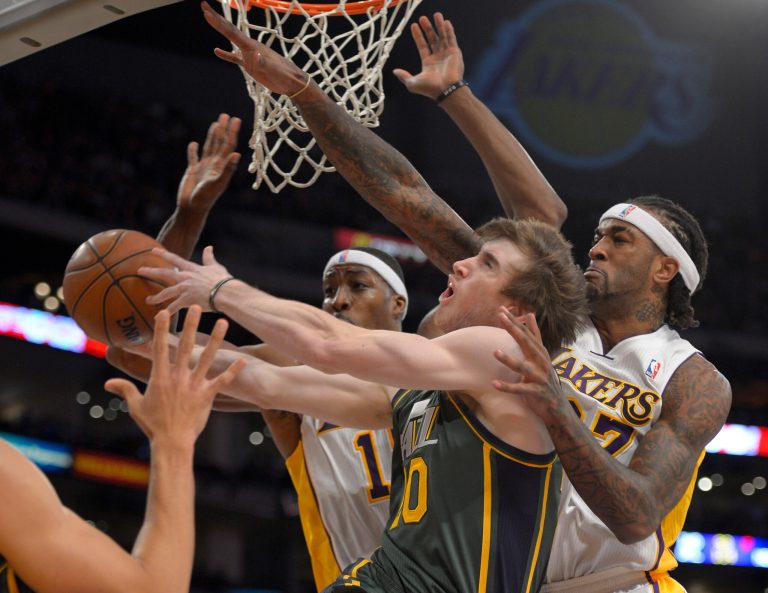   Utah Jazz guard Gordon Hayward, middle, drives to the basket between Los Angeles Lakers' Dwight Howard, left, and Jordan Hill during the first half of their NBA basketball game, Sunday, Dec. 9, 2012, in Los Angeles. (AP Photo/Mark J. Terrill)  