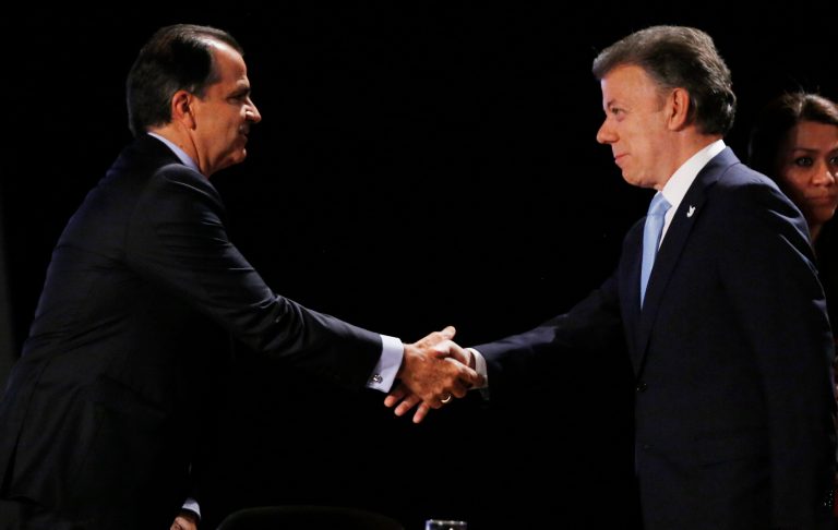 President Juan Manuel Santos, right, who is seeking a second four-year term as candidate for the Social Party of National Unity in the upcoming May 25 presidential election, shakes hands with Oscar Ivan Zuluaga, candidate for the Democratic Center, prior to a televised presidential debate in Bogota, Colombia, Thursday, May 22, 2014. Colombia will hold presidential elections on May 25. (AP Photo/Fernando Vergara)